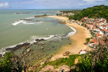 view of a town on a sandy beach near green trees