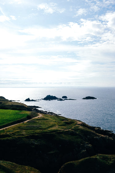 view of green hills by dark blue water