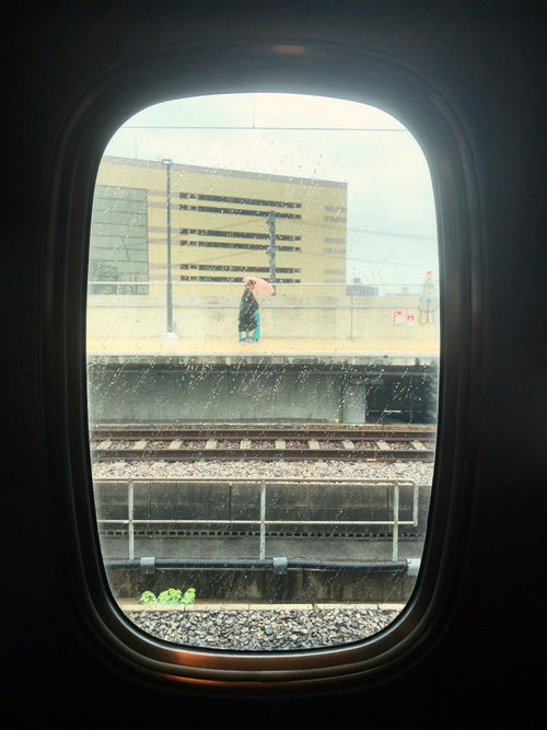 view through a train window in the rain