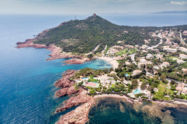 village beside rocky shore and green hill