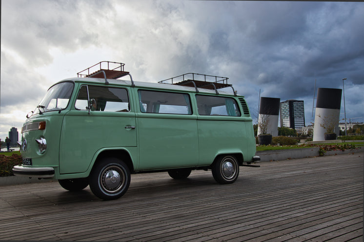 vintage-teal-camper-van-parked-on-a-wood