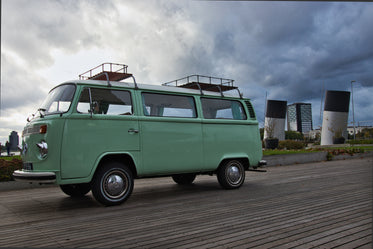 vintage teal camper van parked on a wooden walkway