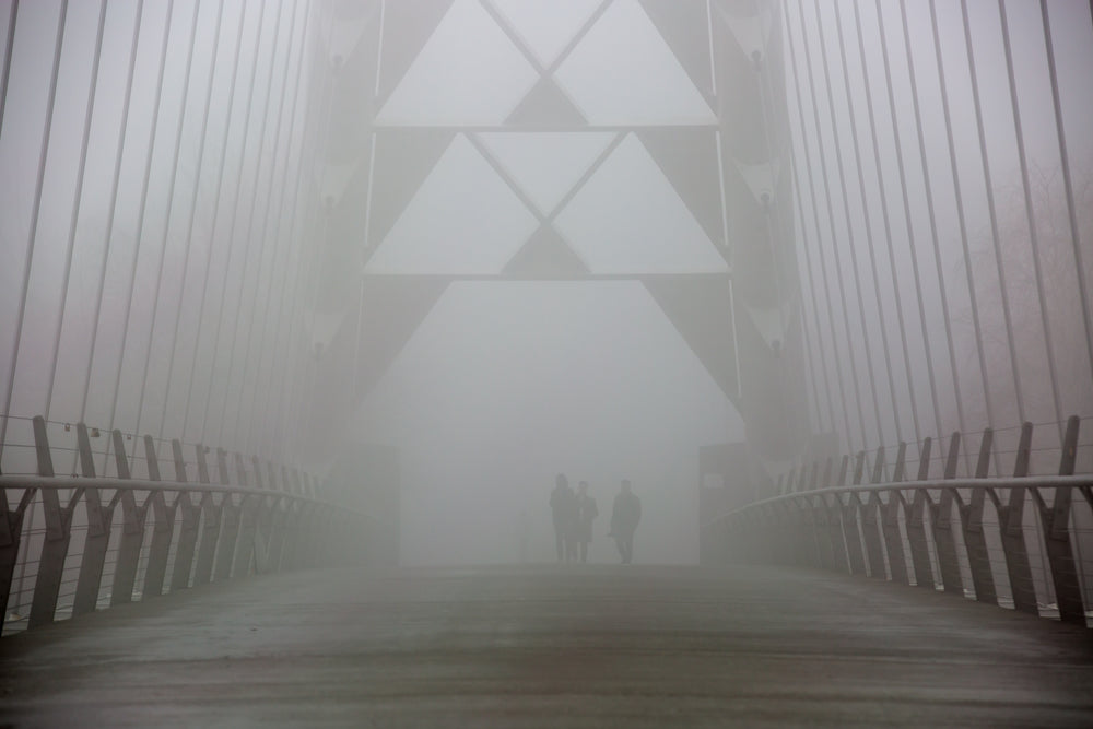 walkers on foggy bridge