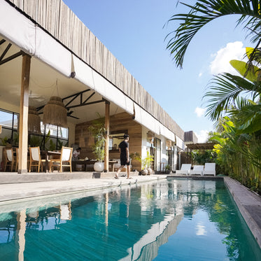 walking along the edge of an aqua blue outdoor pool