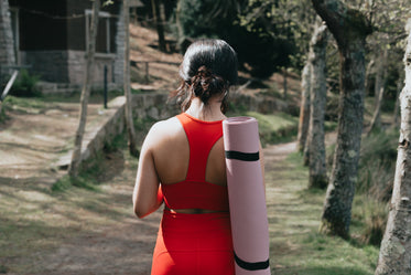 walking away from camera carrying a yoga mat