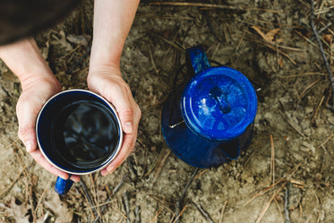 warming hands on campfire coffee