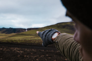 watch and gloves on hand pointing