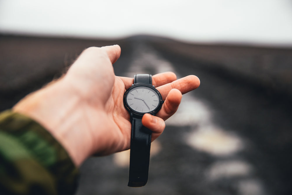 watch held in hand over road