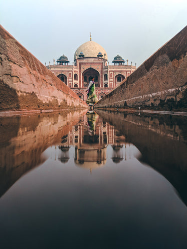 water from a thin canal reflects the taj mahal