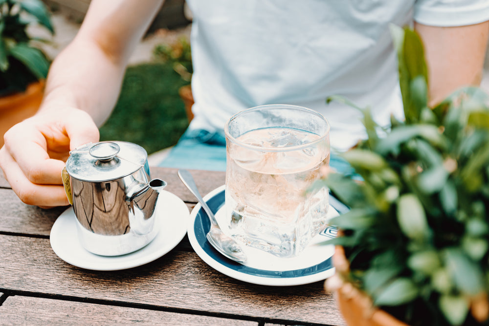water glass and teapot on an outdoor wood table