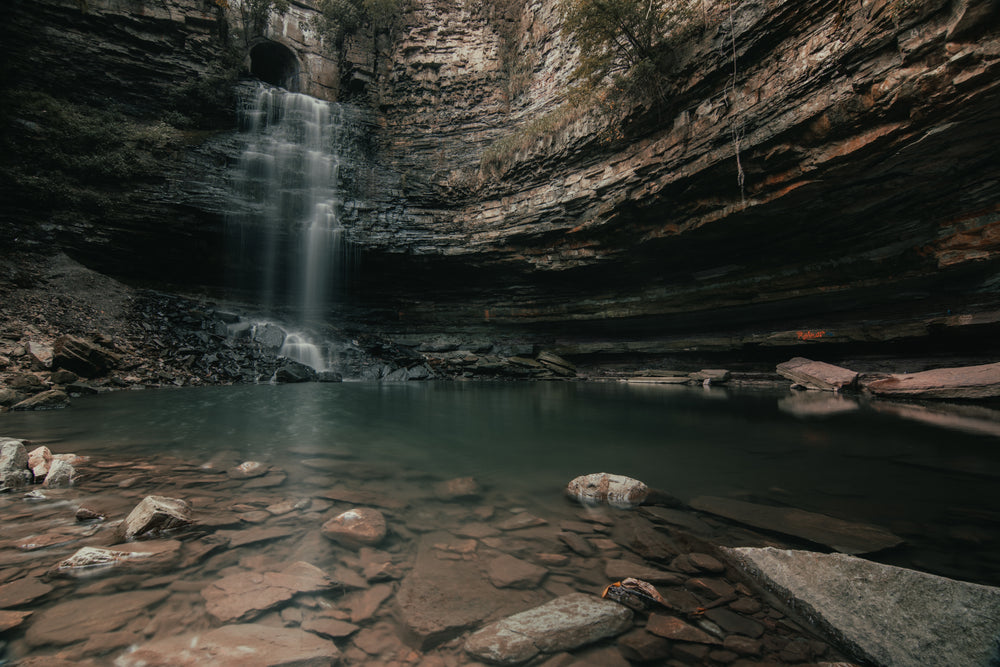 waterfall cascading through cave tunnel