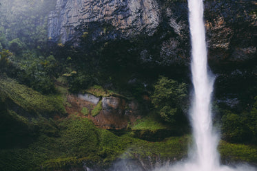 waterfall from rock formations over grass