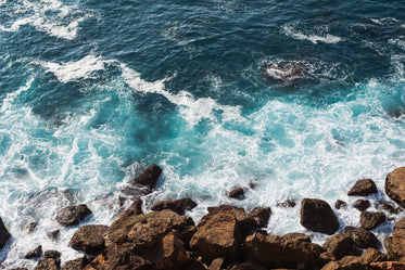 waves crash over rocks on the shore