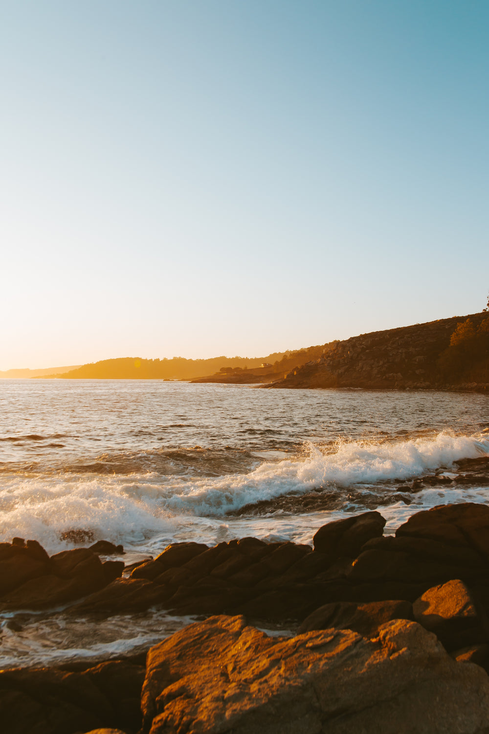 waves crash under morning sun