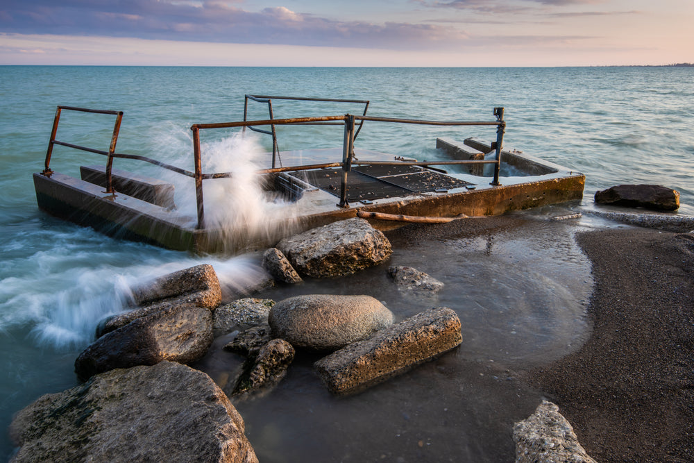 waves crashing over beach structure