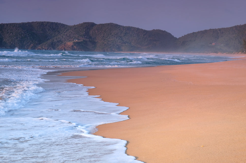 waves lap the shore of a sandy beach