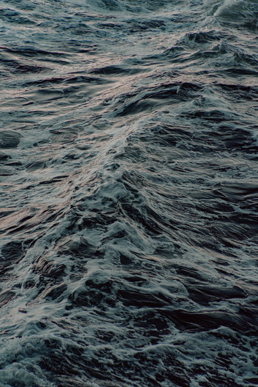 waves moving through the ocean at dusk