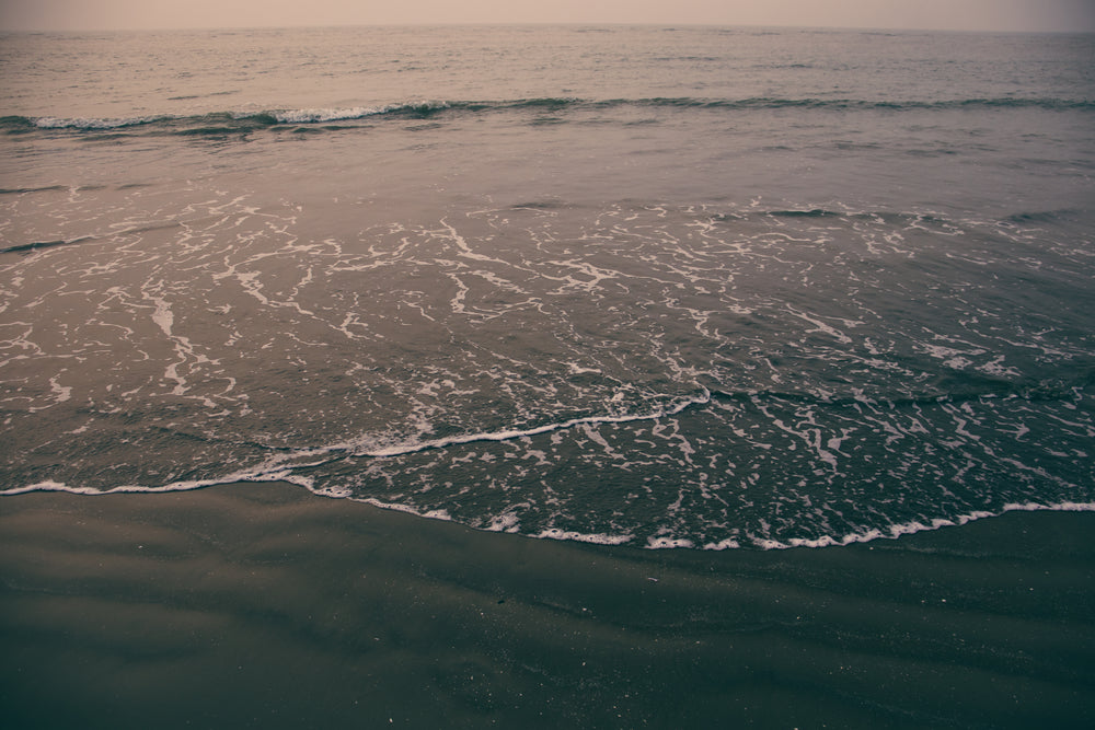 waves reaching the wet sand on shore