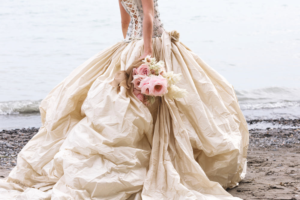 wedding gown and bouquet near beach