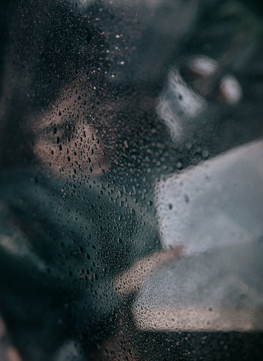 wet glass with a person reading behind it