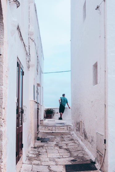 white alleyway with person at the end taking in the view