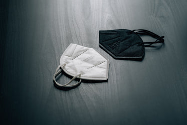 white and black masks lay on a wooden surface