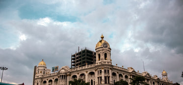 white and gold building with arches and clock towers