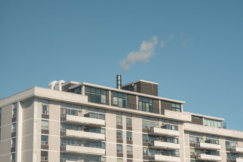 white apartment building with smokey chimney