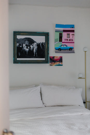 white bed with ecclectic art on the wall