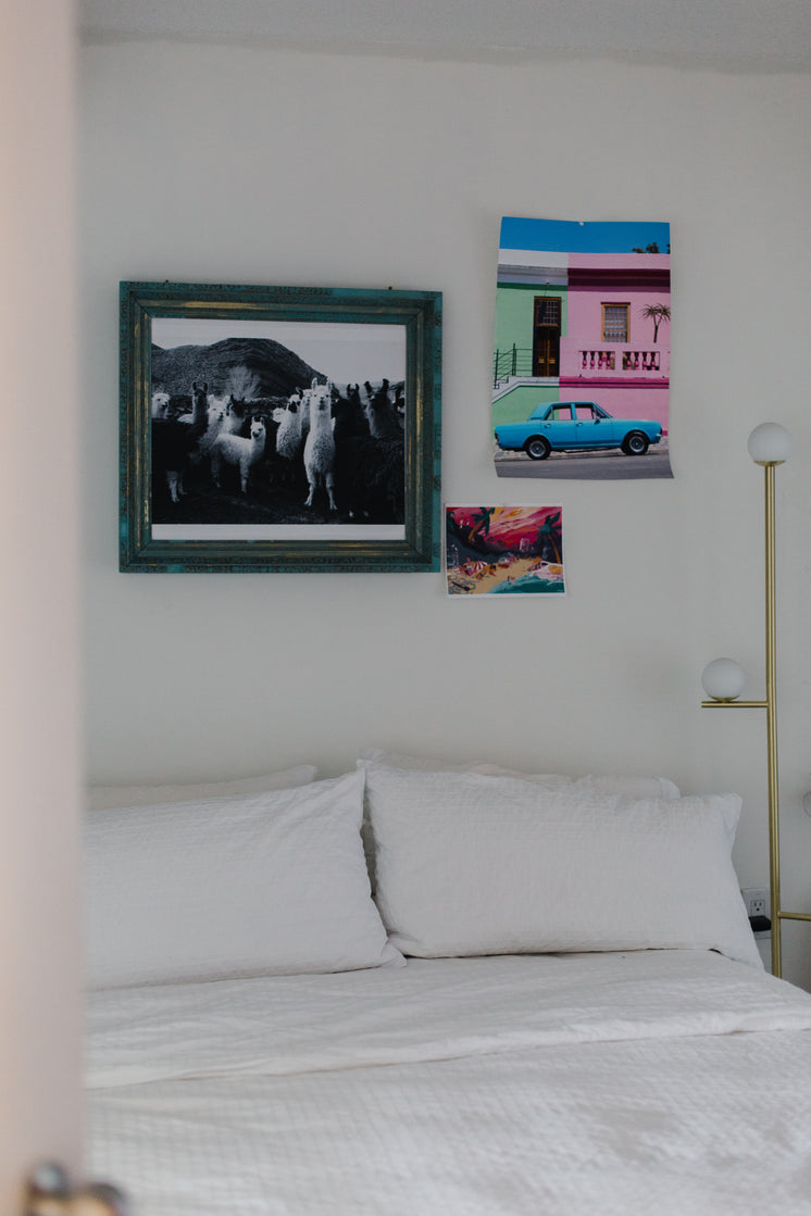 White Bed With Ecclectic Art On The Wall