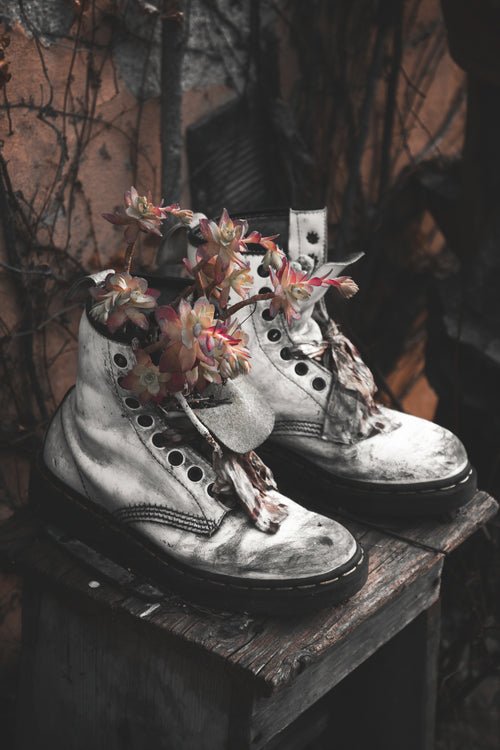 white boots filled with pink flowers