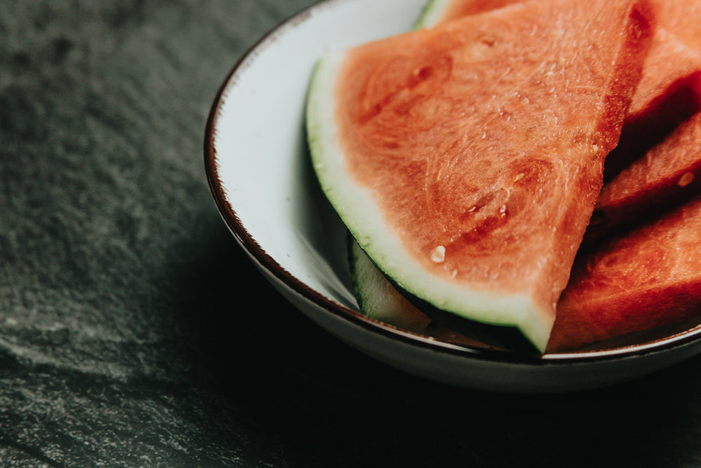 white bowl filled with slices of watermelon close up