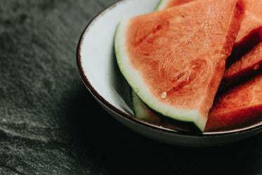 white bowl filled with slices of watermelon close up