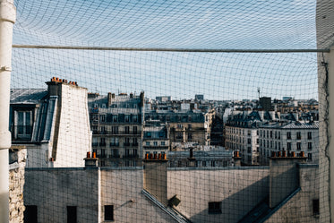 white buildings viewed through a wire fence