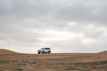 white car in the red desert sand