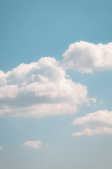 white clouds in a soft blue sky on warm summer day