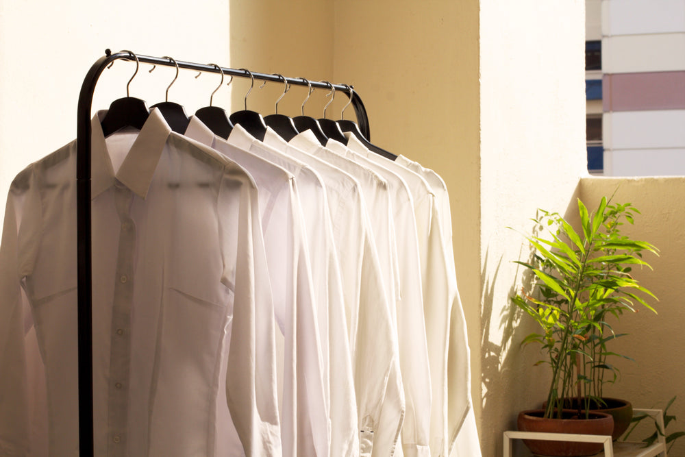 camisas de gola branca em arara ao sol