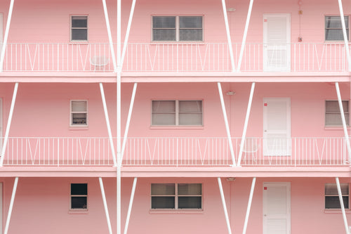 white doors and railings in a pink apartment block