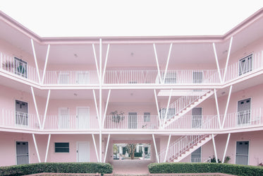 white doors and railings in a pink multi-storey block