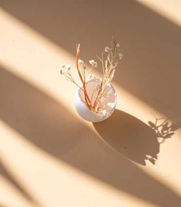 white egg shell with dried flowers on beige