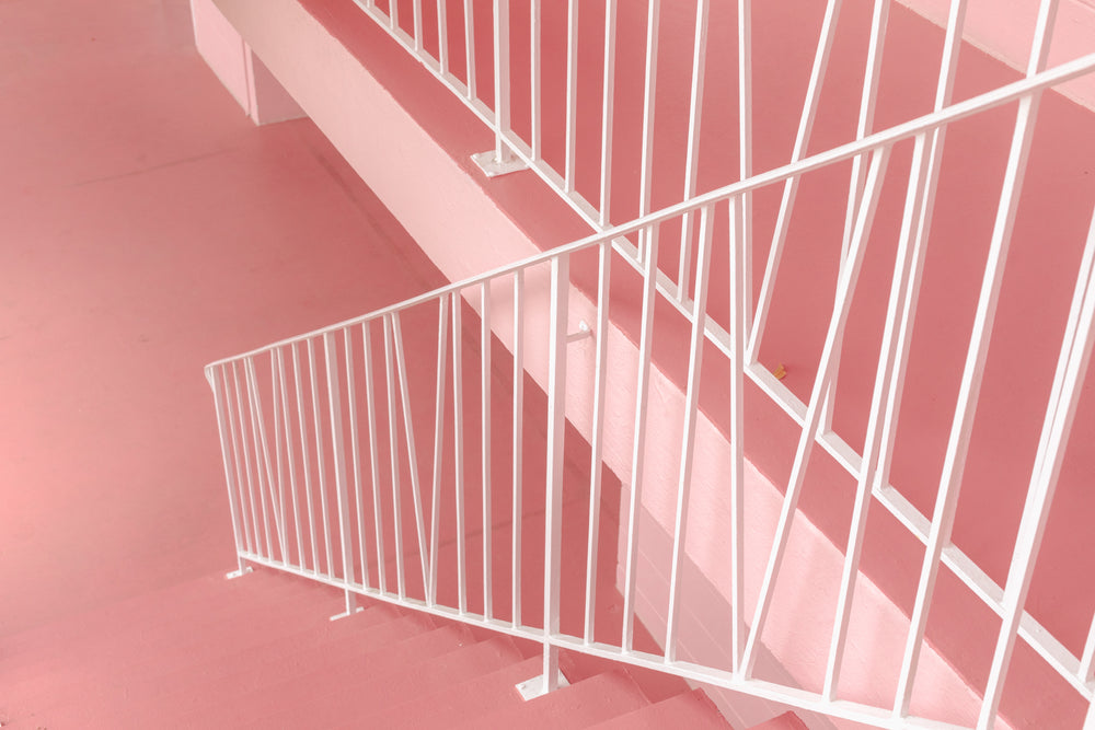 white metal railings cross pink stairs and landings