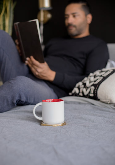 white mug coaster sits on a grey blanket