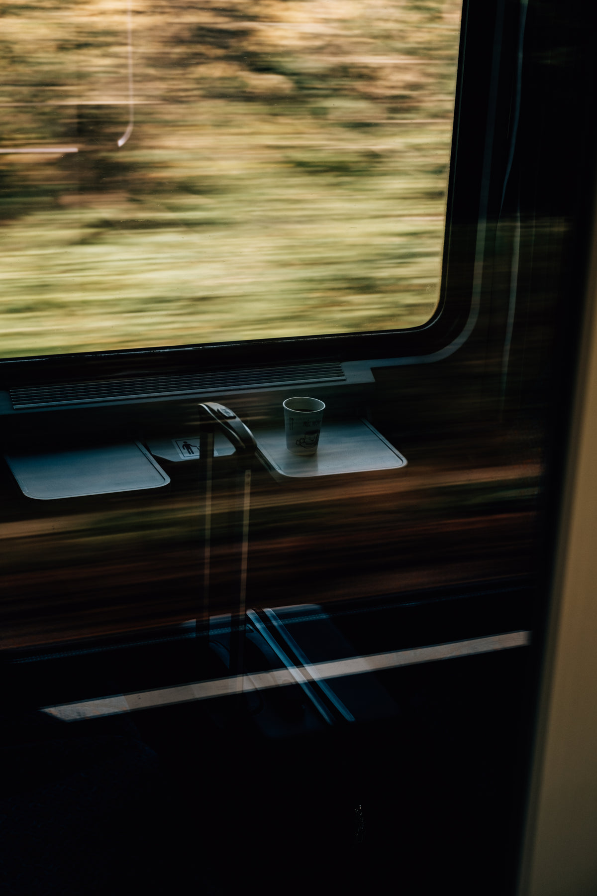 在快速行驶的火车上，白色纸杯和手提箱