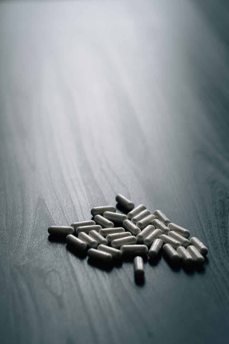 white-pills-on-a-grey-wood-grain-surface