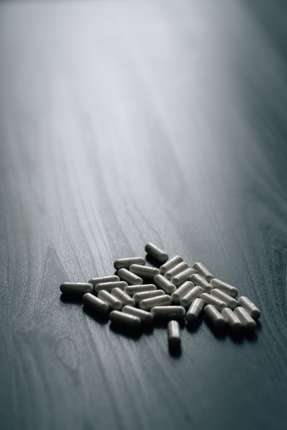 white pills on a grey wood grain surface