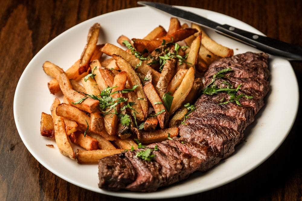 white plate with fries and a grilled steak