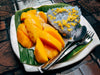 white plate with mango rice and cutlery