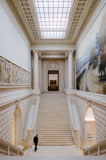 white room with person in black walking up stairs