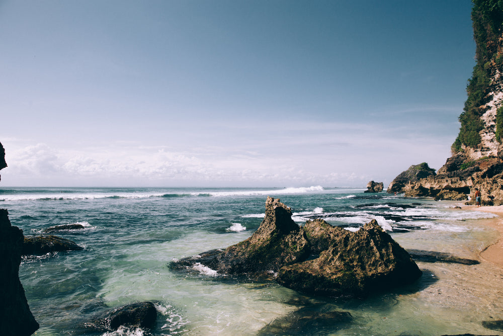 white sand beach scattered with large boulders