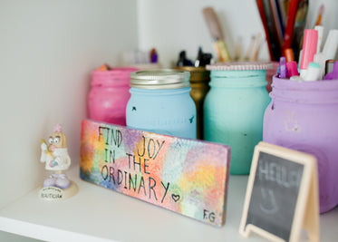 white shelf with art supplies and a sign